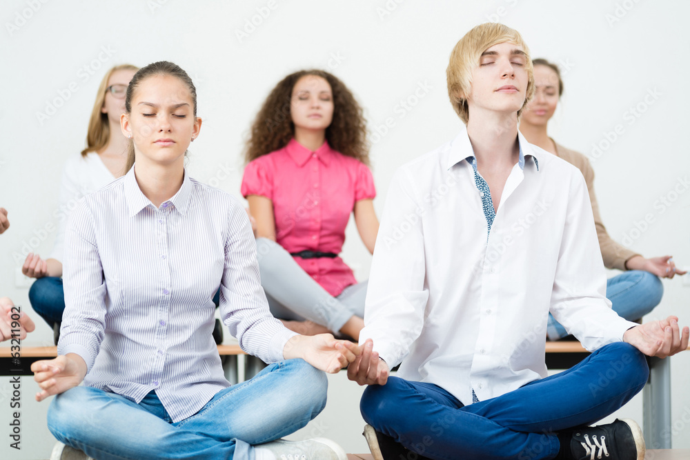 group of young people meditating