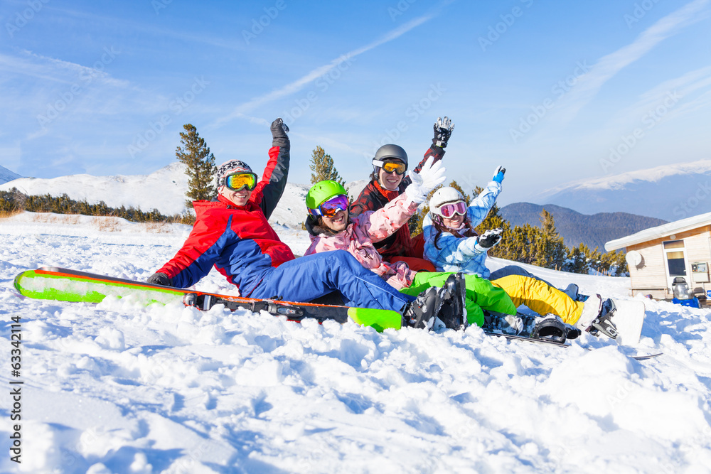 Four happy friends wearing goggles with hands high