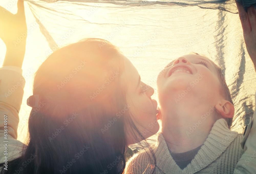 Mother kissing her child druing playing