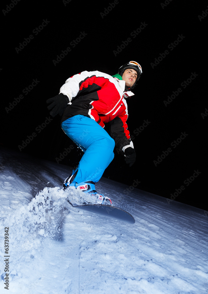 年轻的单板滑雪运动员在夜间滑行