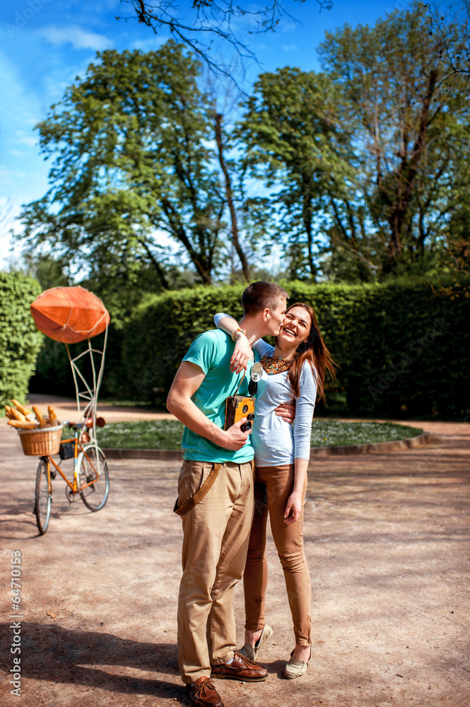 Lovely young couple standing and hugging near the bicycle with r