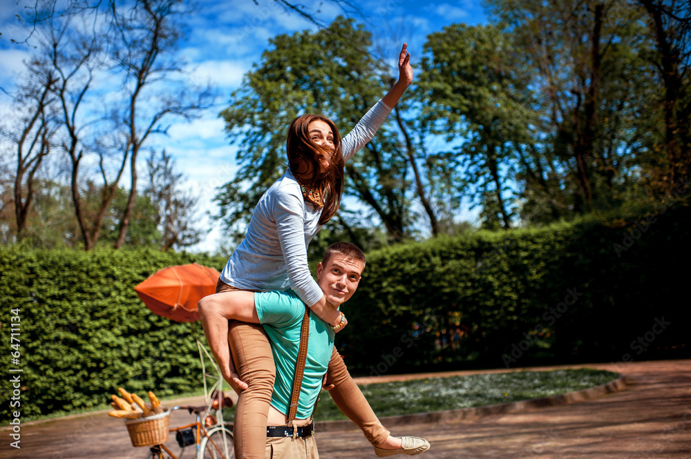 Lovely young couple having fun near the bicycle with red dirigib