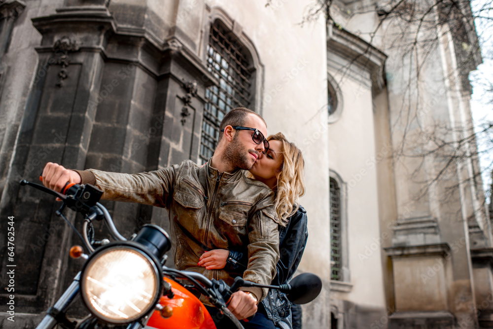 Couple sitting on the motorcycle in the city park