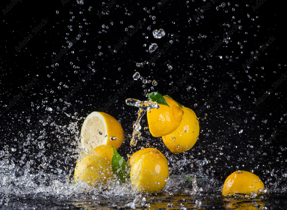 Lemons in water splash on black background