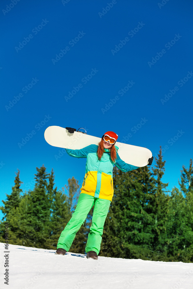 Happy girl in ski mask holding snowboard