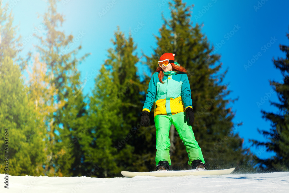 戴着滑雪面罩的女孩在滑雪板上骑行