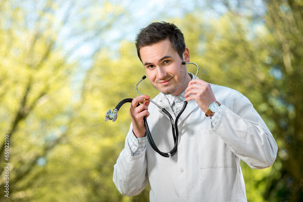 Young doctor listening with stethoscope