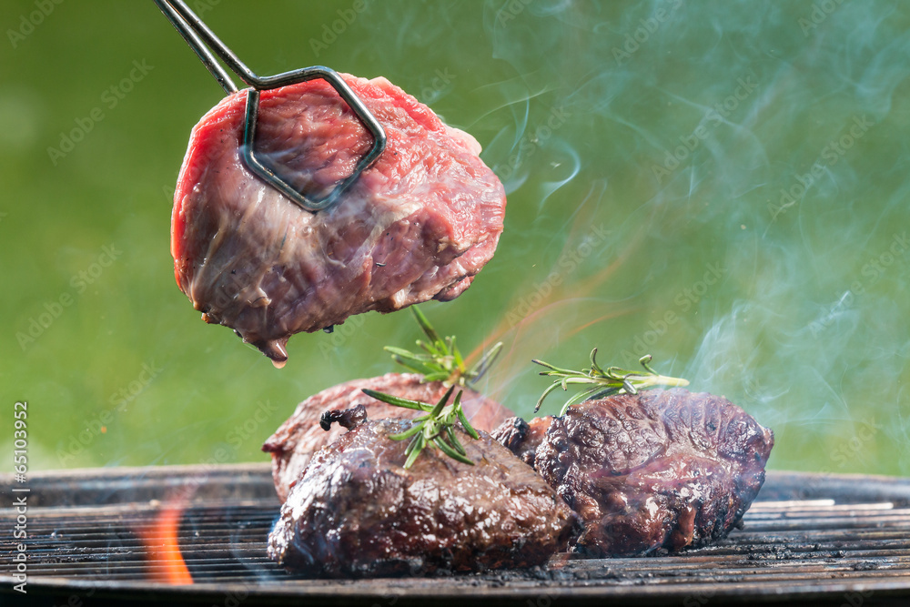 Grilled beef steaks on fire