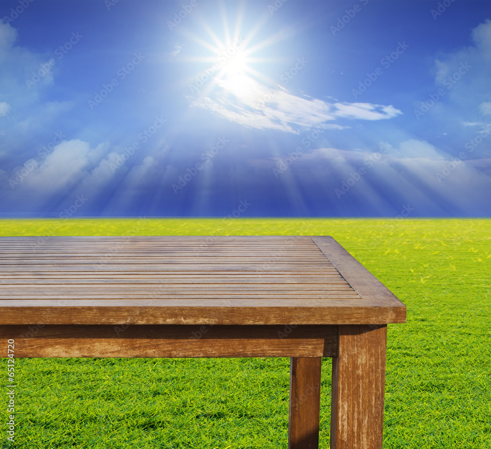 empty free space top wood table on green grass field against sun