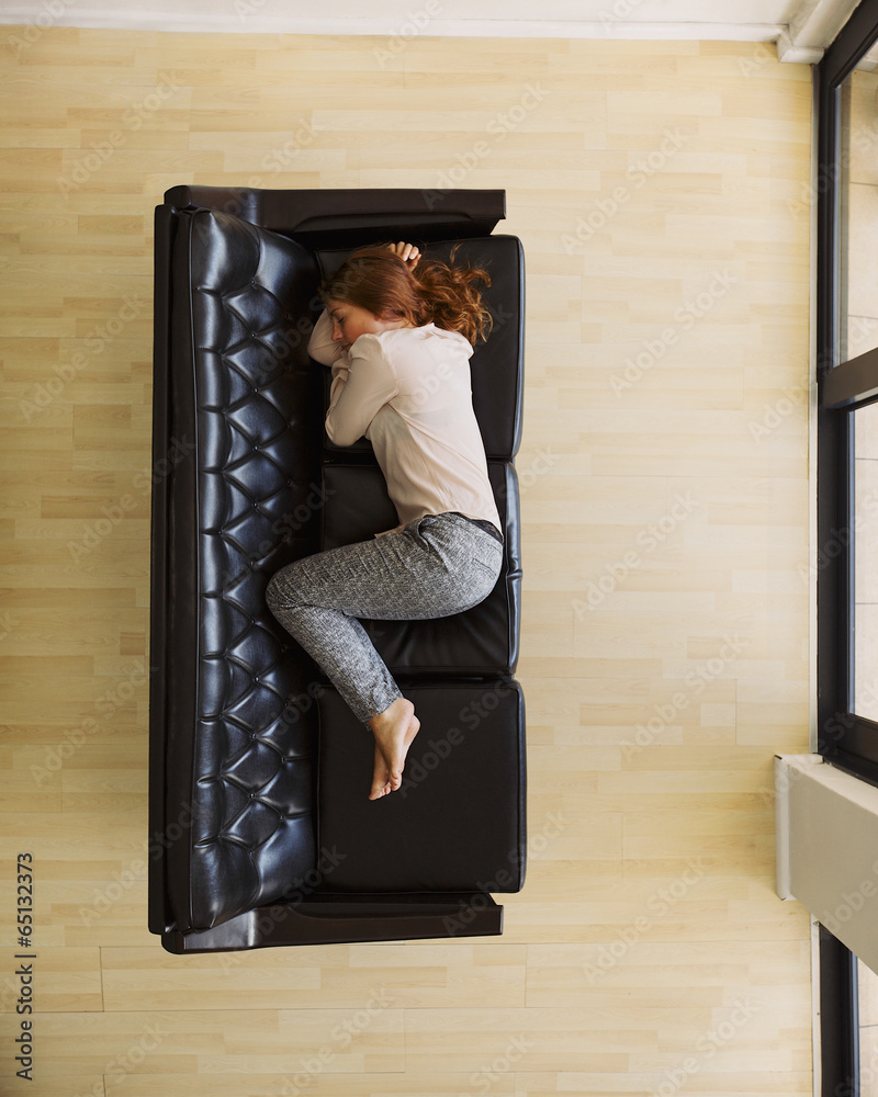 Aerial view of young female sleeping on couch