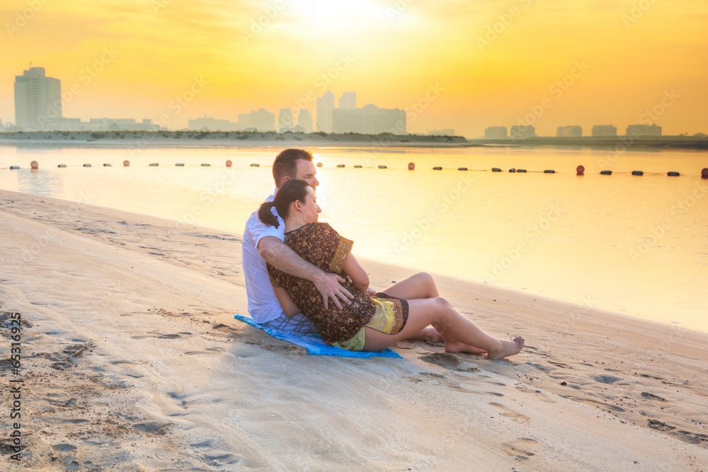 Couple watching romantic sunrise on the beach of Abu Dhabi