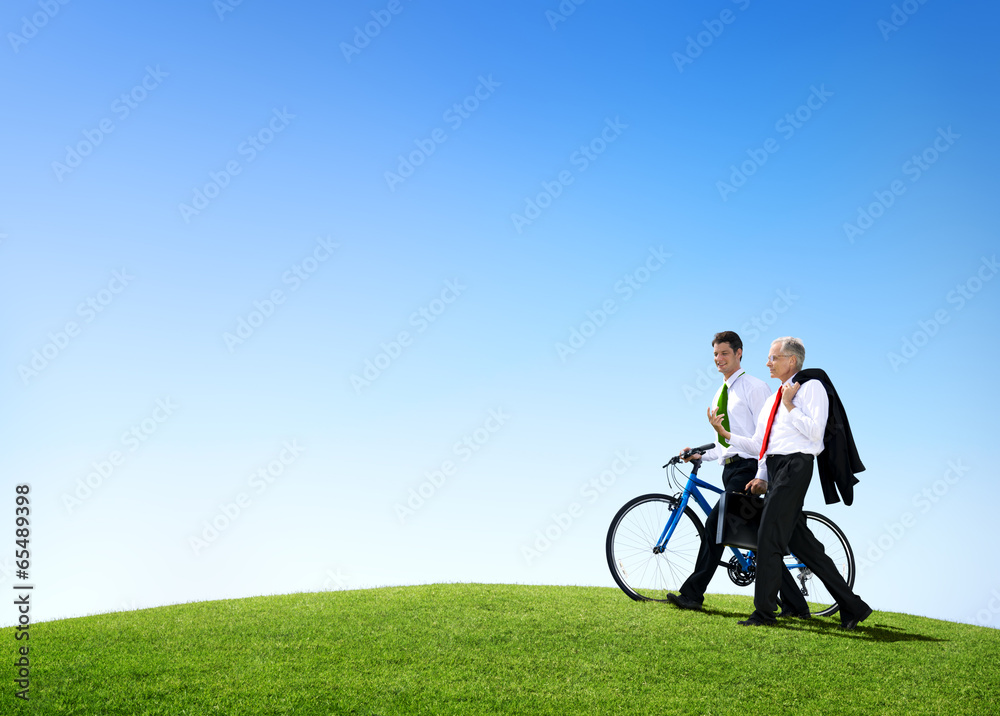 Business Men Walking Through the Field with a Bicycle