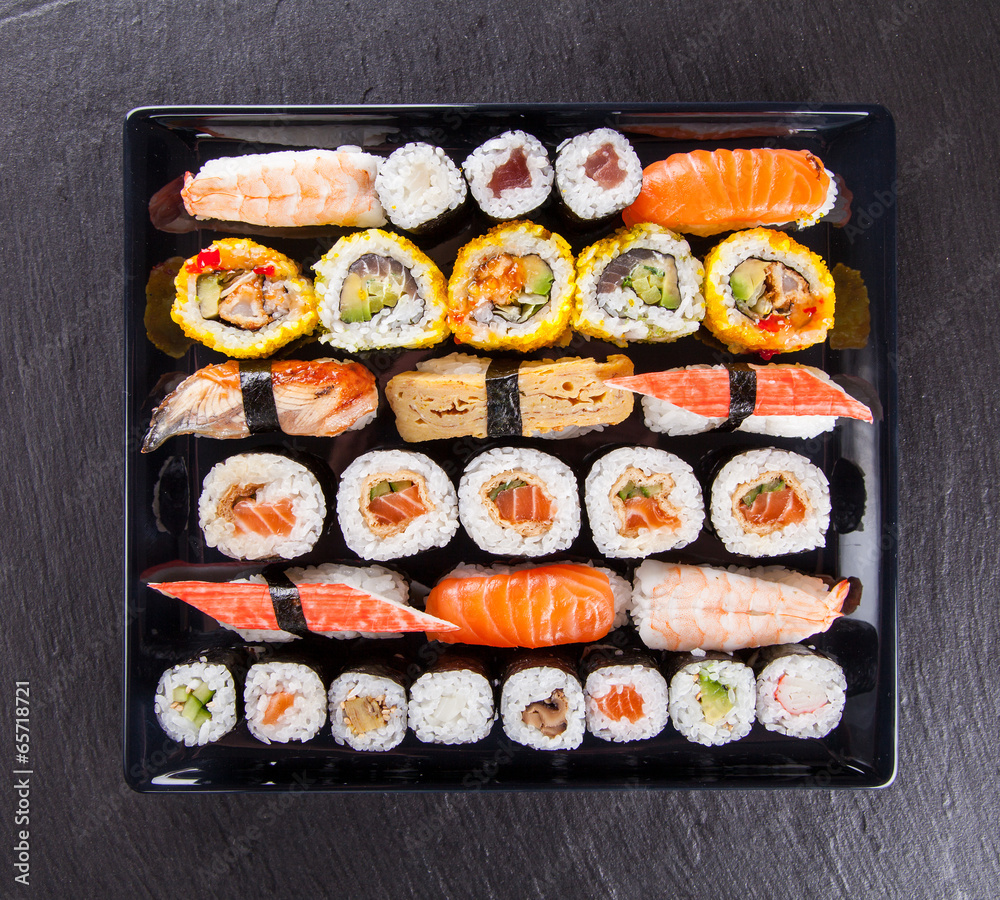 Delicious sushi pieces served on black stone