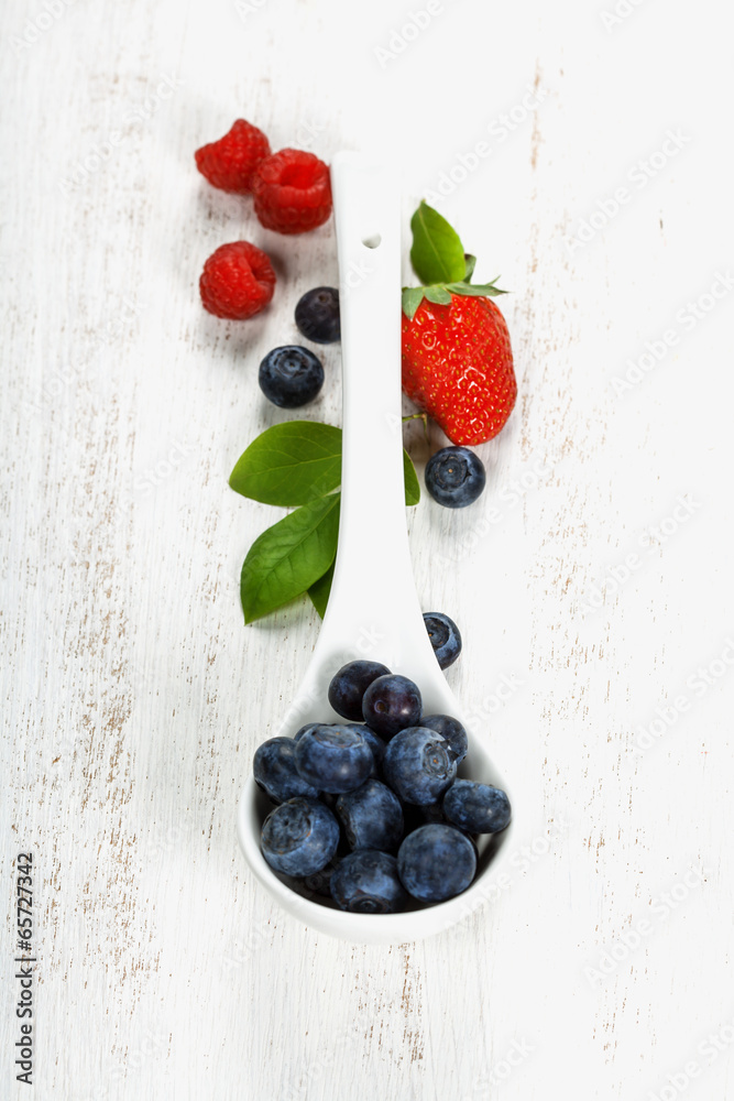 Berries with spoon  on Wooden Background.