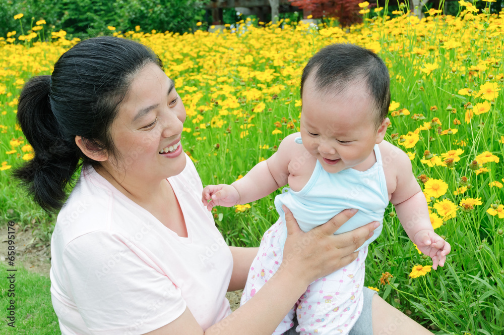 东方妈妈和她的孩子一起在公园玩耍