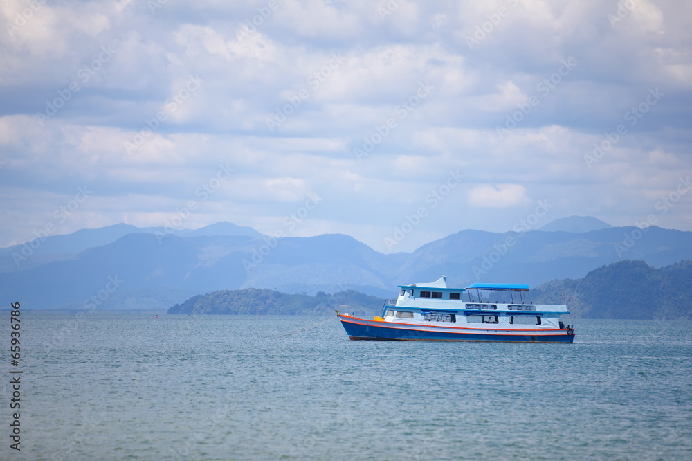 Fishing boat in a sea and cloudy sky