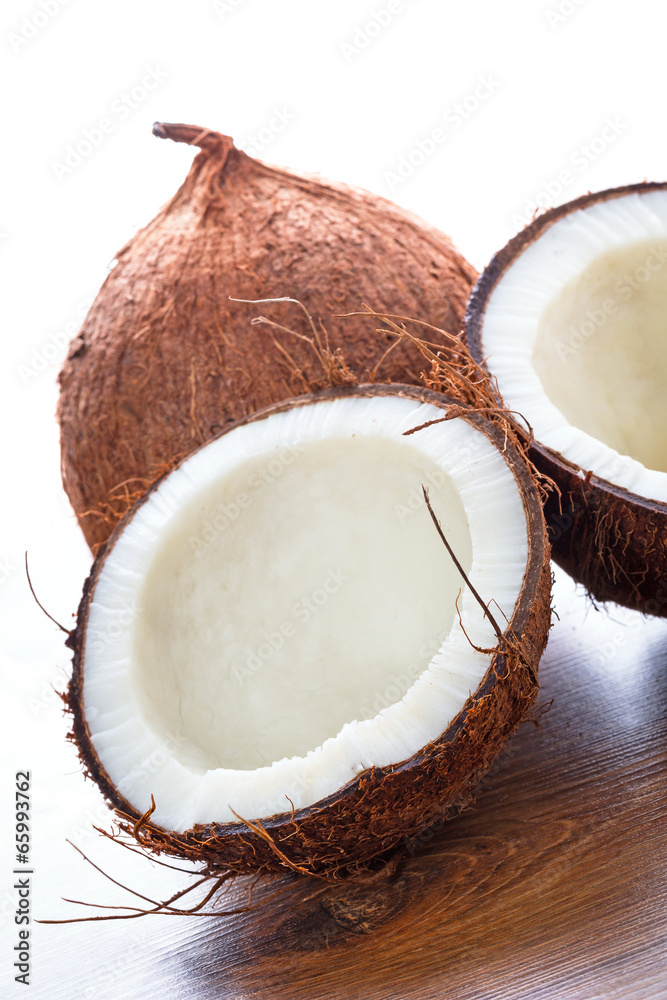 Coconut cut in half on wooden board