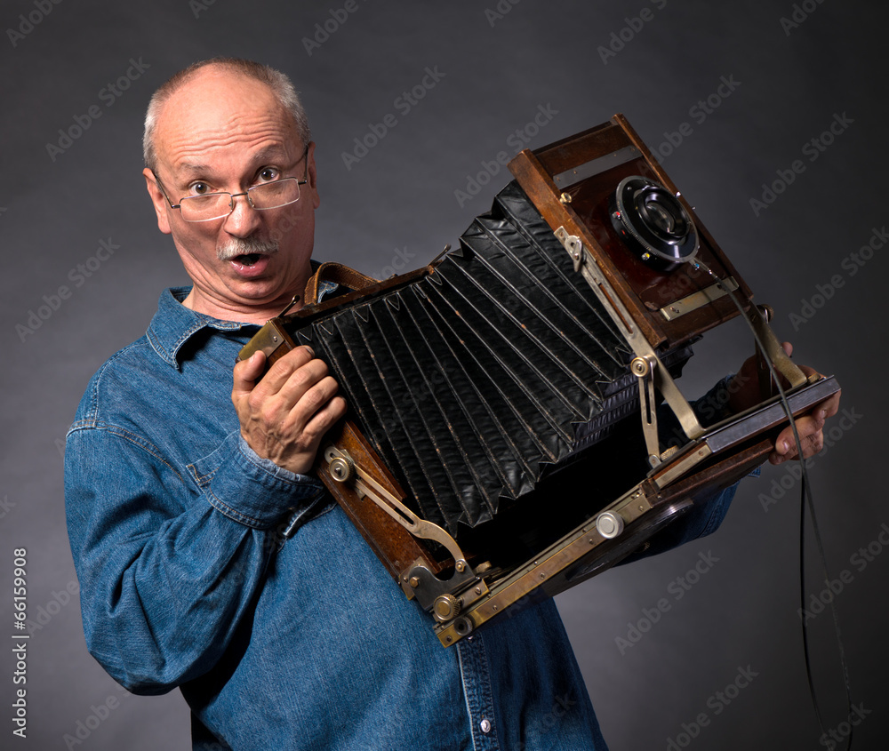 Man with vintage wooden photo camera