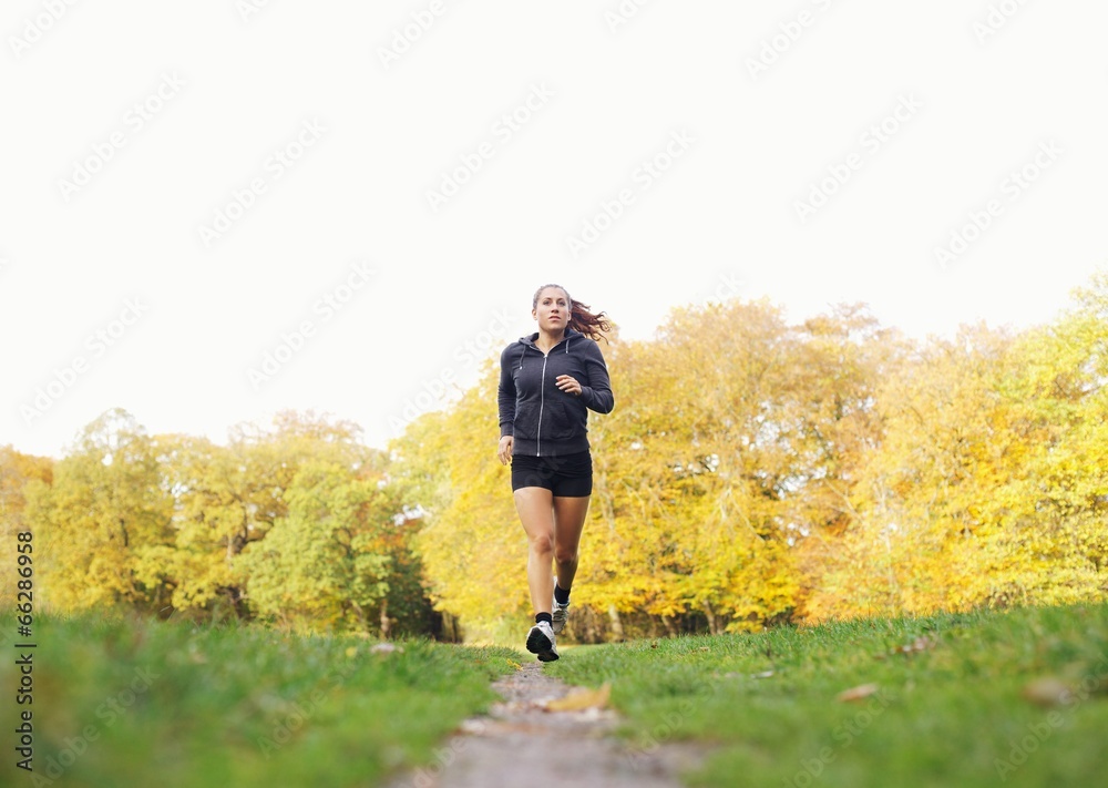 健康快乐的年轻女子在公园跑步