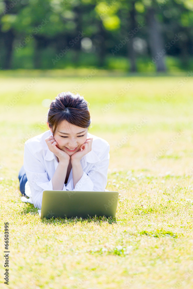 亚洲年轻女子在公园里使用电脑