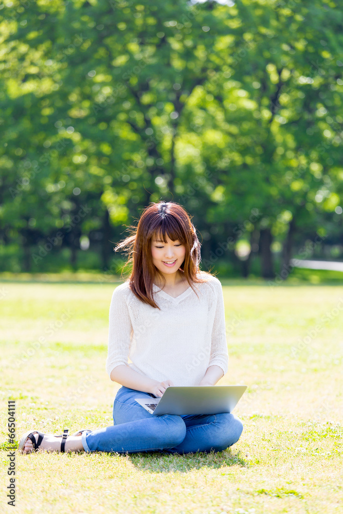 亚洲年轻女子在公园里使用电脑