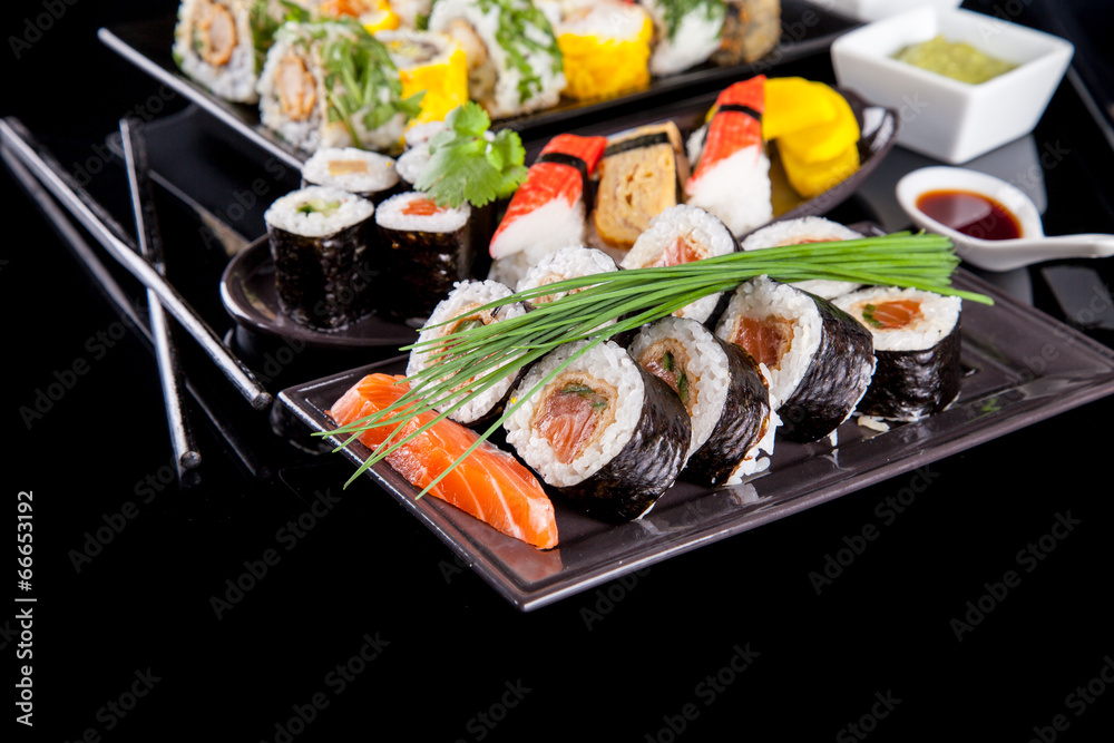 Delicious sushi pieces on black background