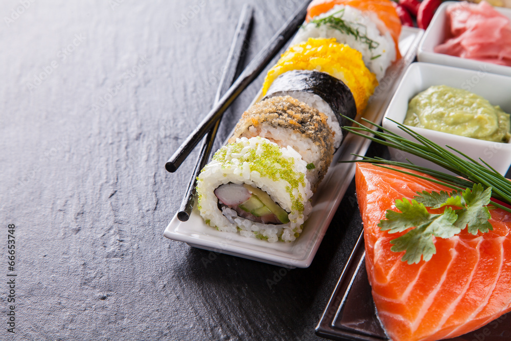 Delicious sushi pieces served on black stone