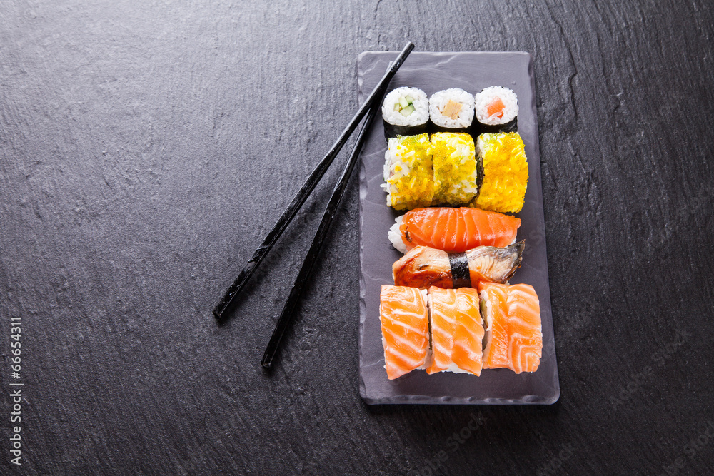 Delicious sushi pieces served on black stone