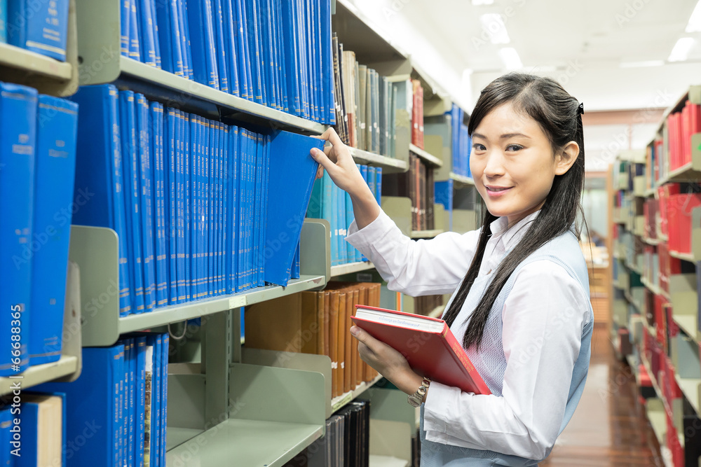 亚洲女学生在图书馆选书