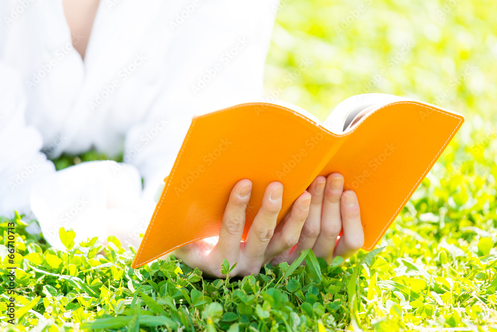 young asian woman reading book in the park