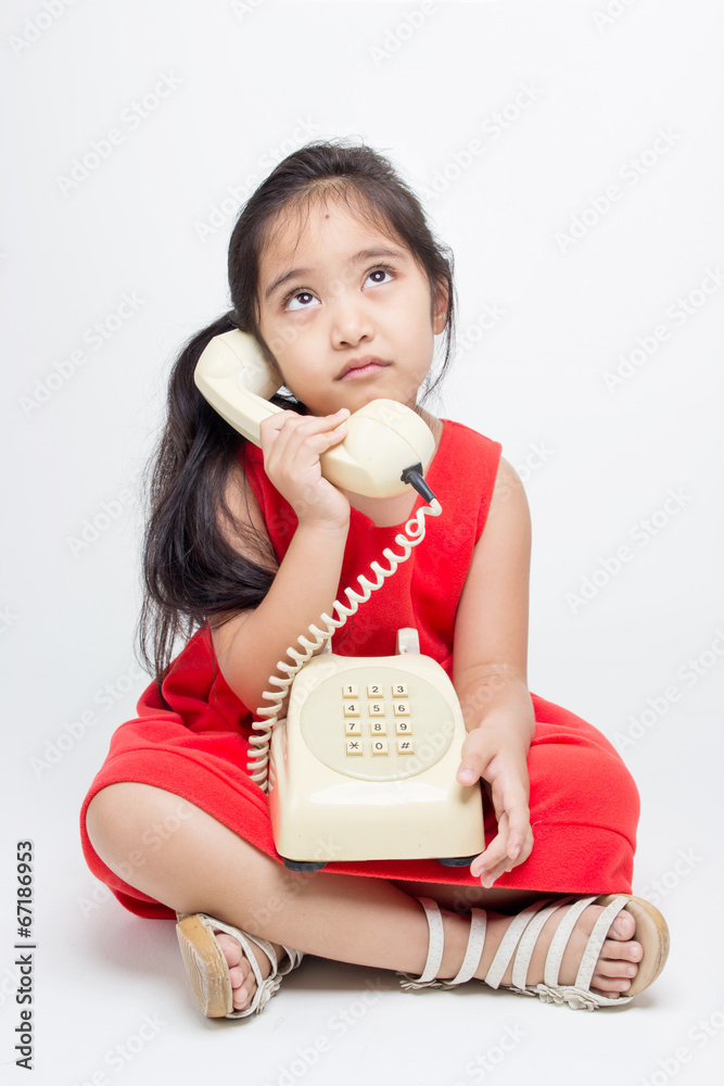 Sadness Asian child in red dress with telephone