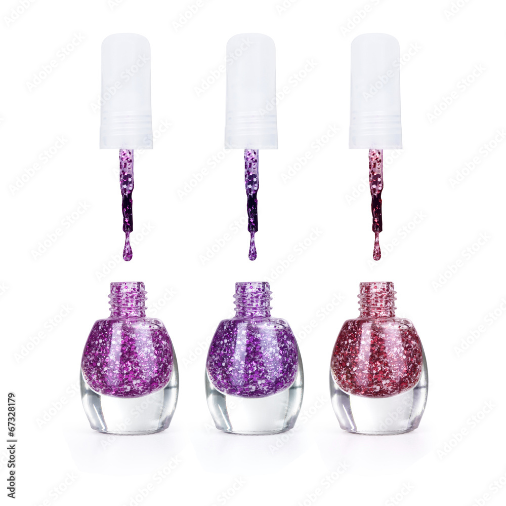 Bottles with spilled nail polish over white background