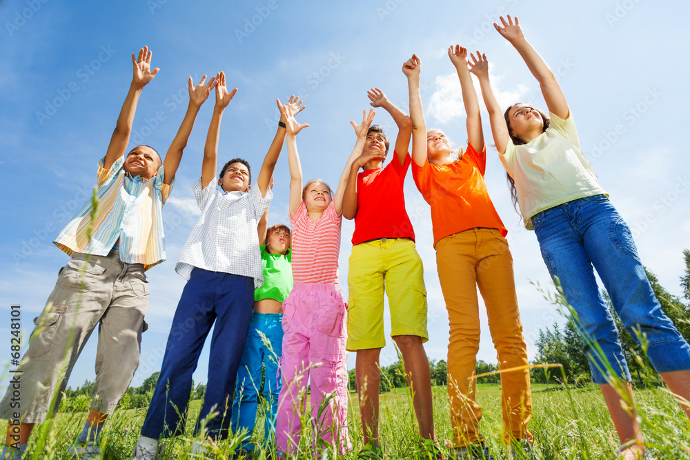 Kids with arms up stand straight in row