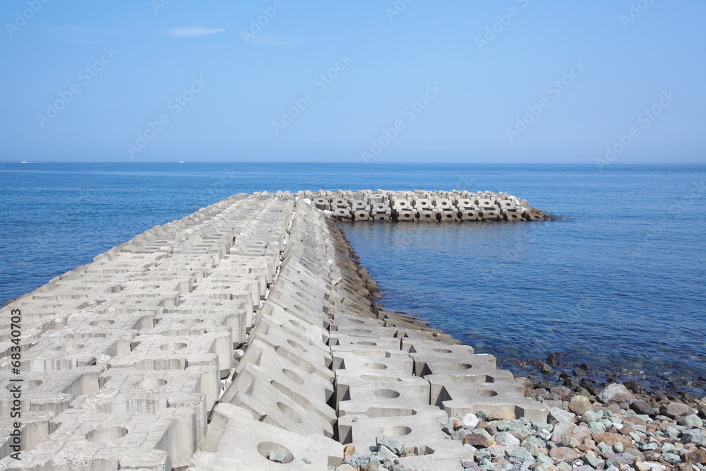 碧海蓝天背景的防波堤混凝土坝