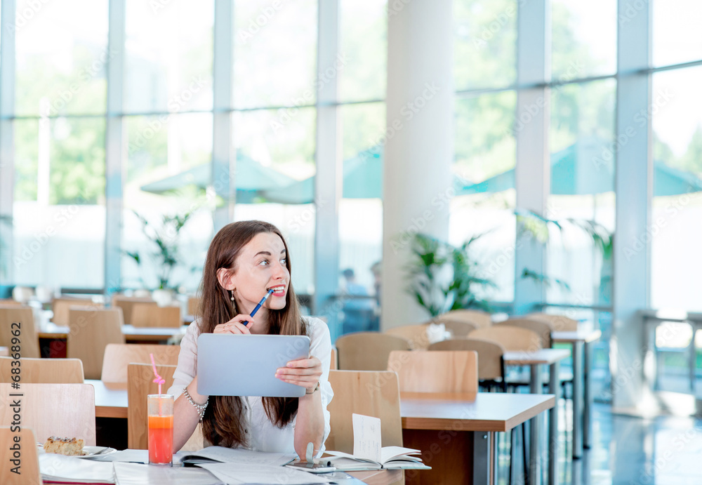 Girl studying in the University canteen with Fresh and cake