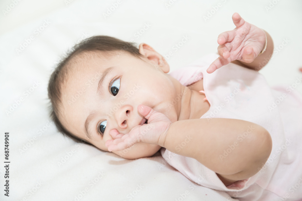 Asian baby sucks his fingers