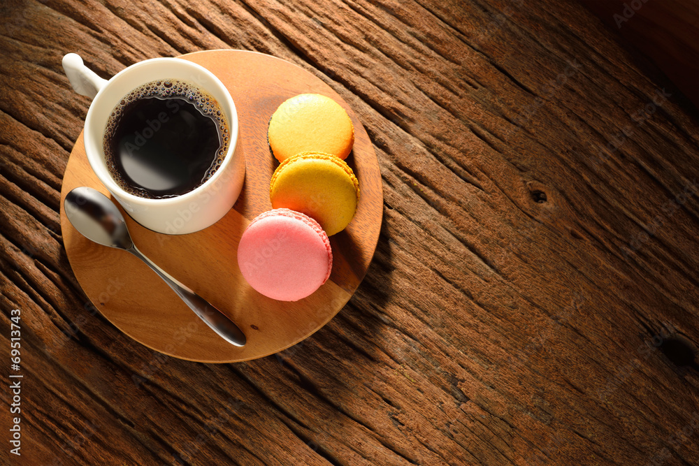 A cup of coffee and pastries(macaron) on old wooden table