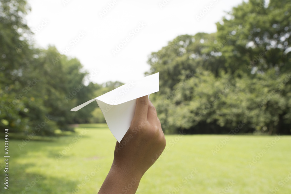 Hand throwing a paper airplane in the air