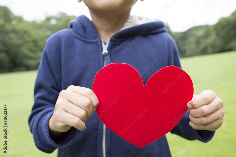 Ｂoy holding a red heart