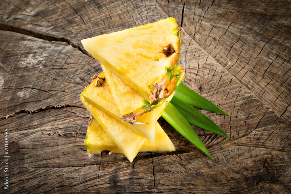 Pineapple slices on wooden background