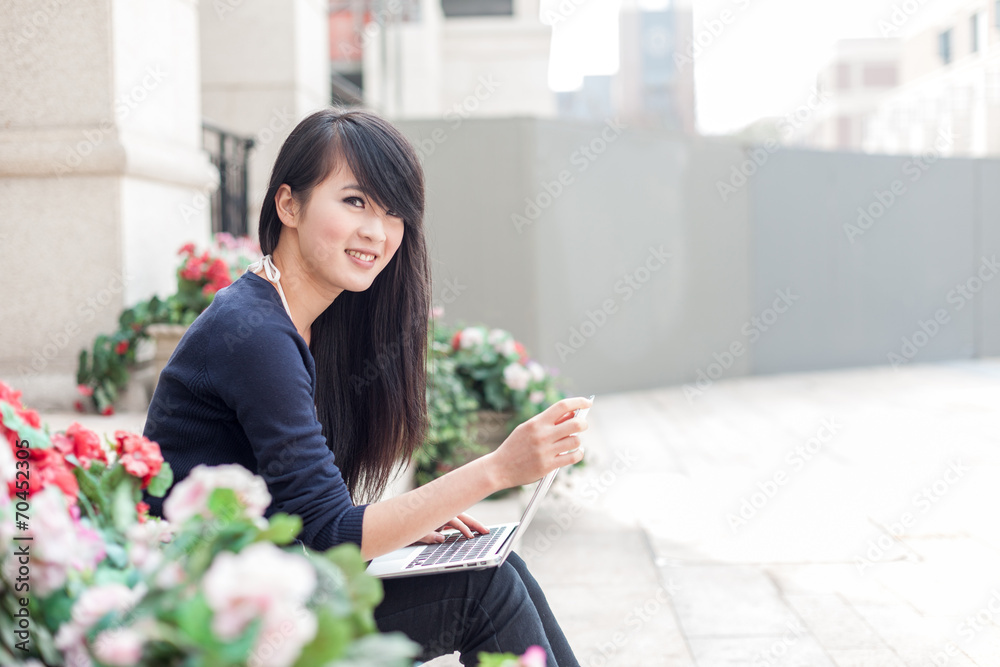 带笔记本电脑的亚洲年轻女性