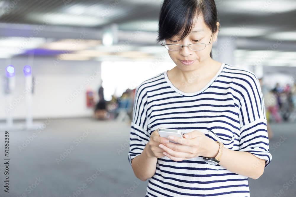 女性在旅游期间用智能手机查看电子邮件