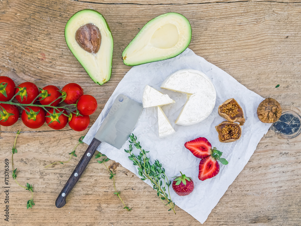 Fresh cheese and vegetable set on a wooden background