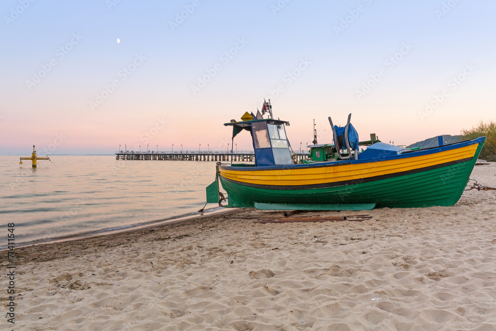 Baltic beach with fishing boat at sunset, Poland