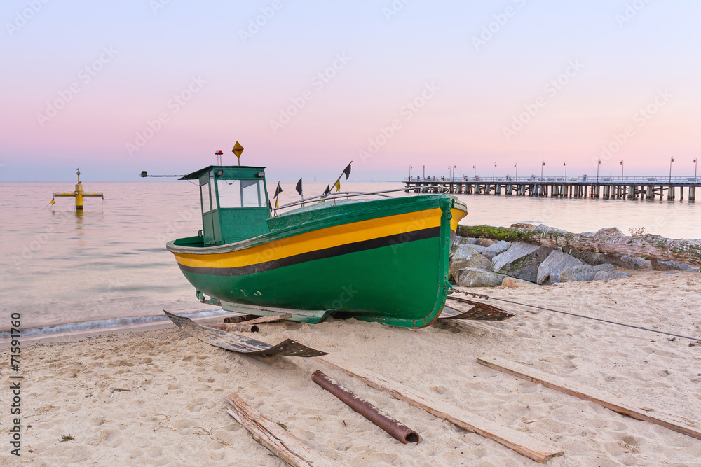 Baltic beach with fishing boat at sunset, Poland