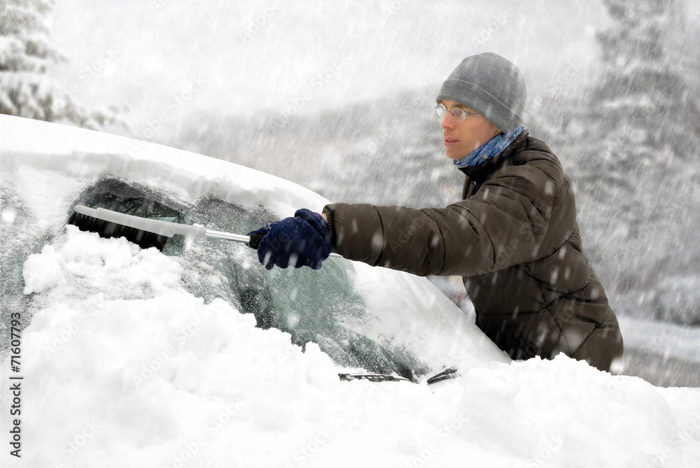 Mann befreit sein Auto vom Schnee