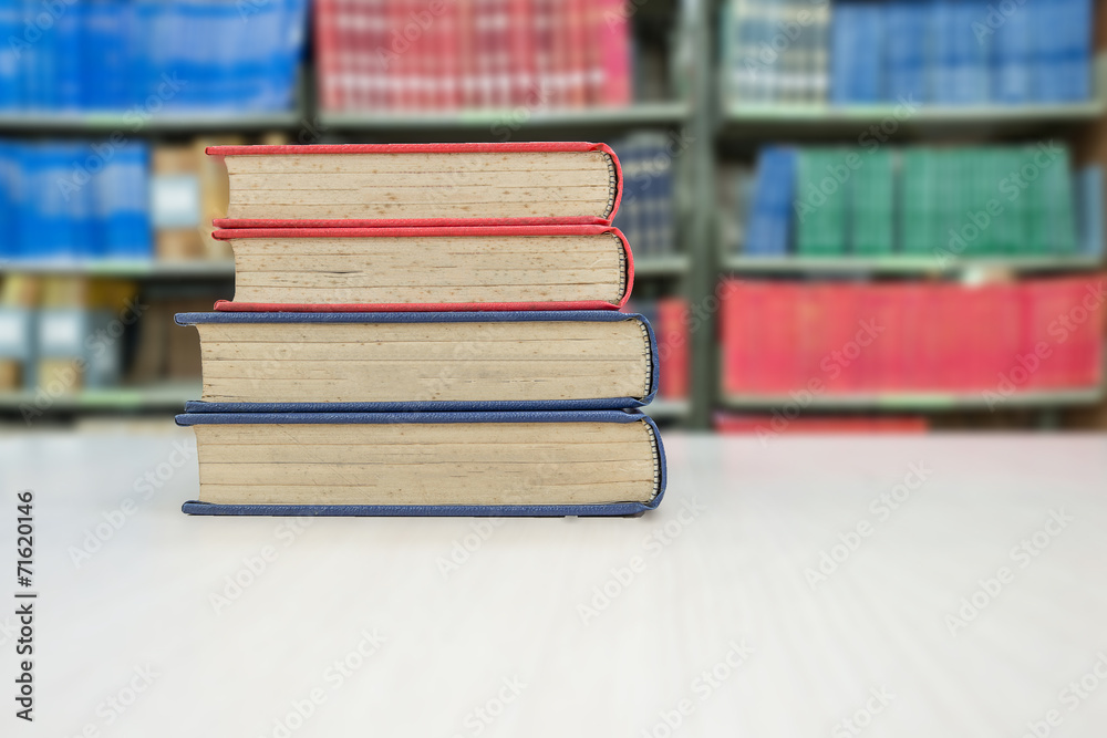 Old book stack on desk in library