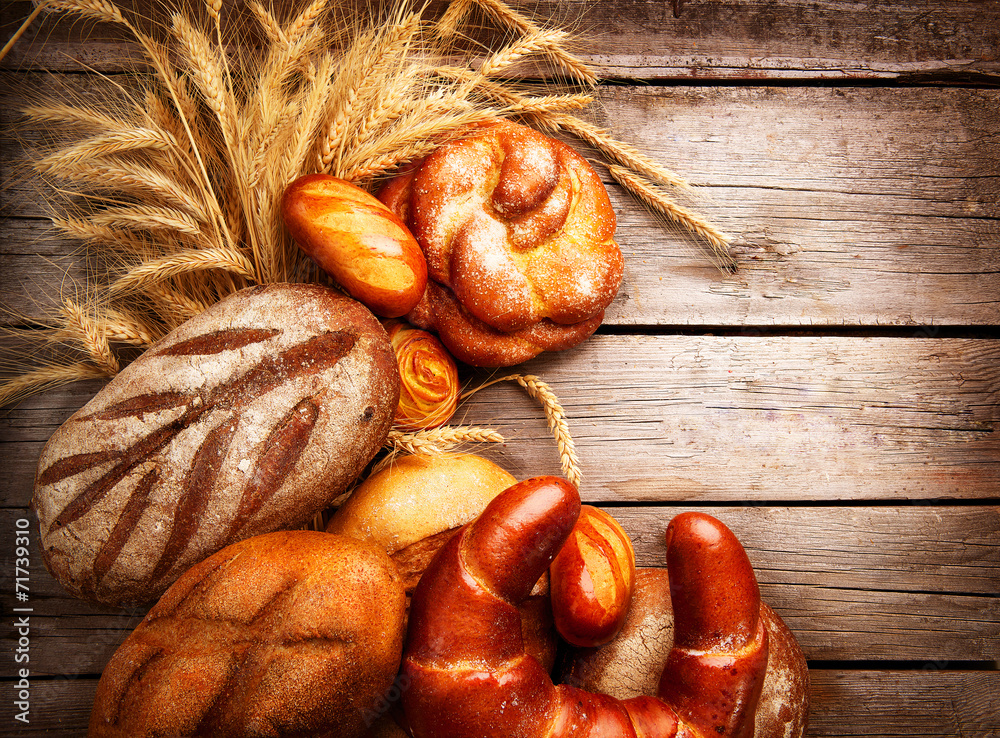 Bakery Bread on a Wooden Table. Bread and Sheaf of Wheat Ears