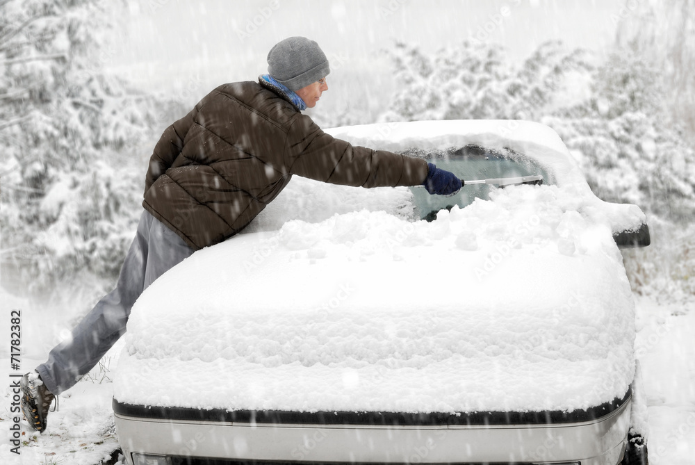 Mann befreit sein Auto vom Schnee