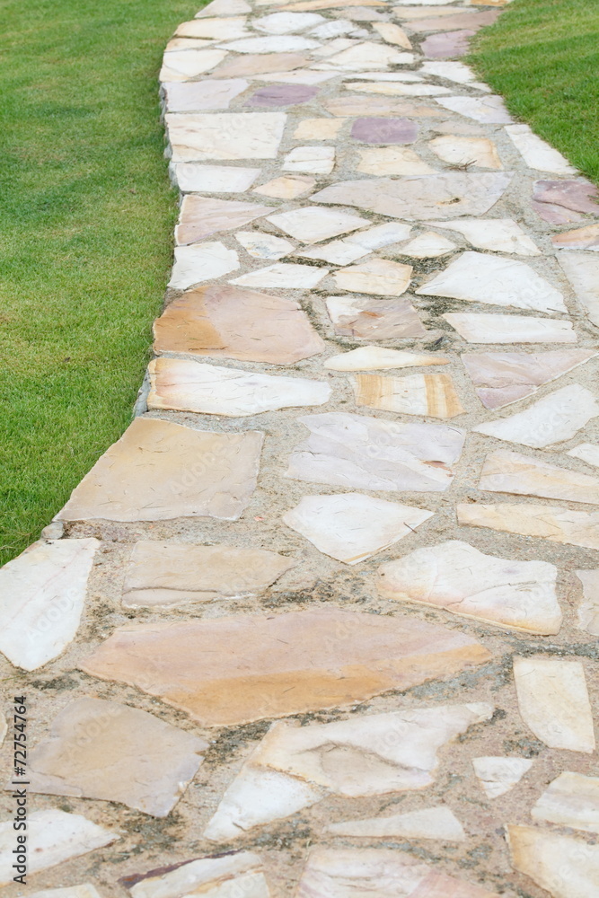 Natural brown stone pathway and green grass